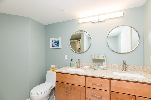 full bath with toilet and double vanity