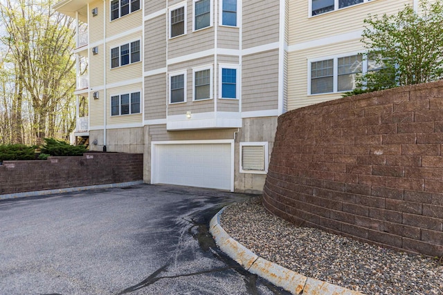 view of building exterior with an attached garage and driveway