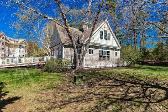 rear view of property featuring a yard and a wooden deck