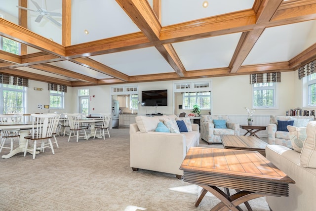 living area featuring coffered ceiling, beam ceiling, a ceiling fan, and carpet floors