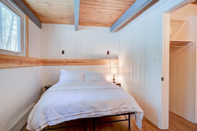 bedroom with wooden ceiling, baseboard heating, and light wood-style floors