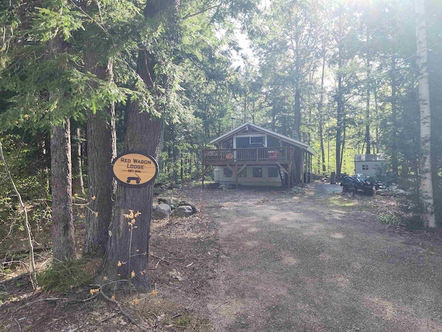 view of front facade featuring a deck and a wooded view