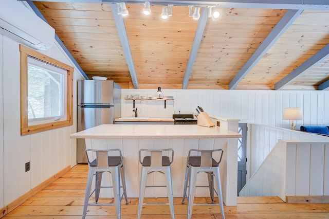 kitchen featuring light wood finished floors, freestanding refrigerator, a wall mounted air conditioner, wooden ceiling, and light countertops