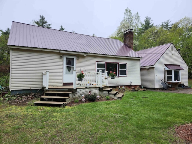 97 Ayers Rd, Canterbury, NH 03224 - back of house featuring metal roof, a chimney, a wooden deck, and a lawn