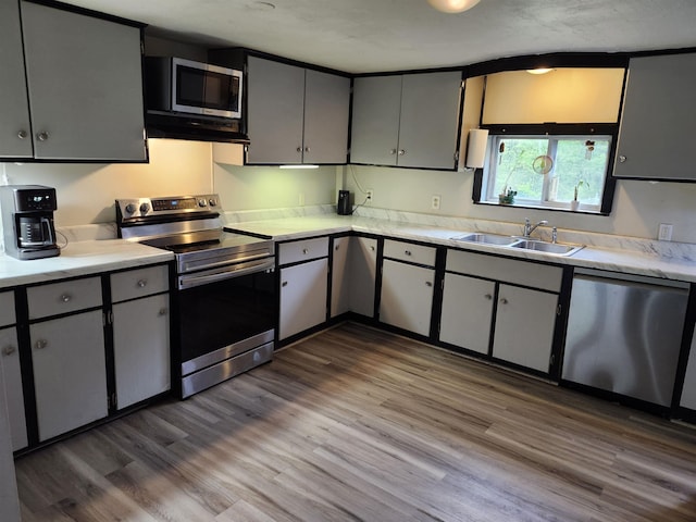 97 Ayers Rd, Canterbury, NH 03224 - kitchen with appliances with stainless steel finishes, a sink, light countertops, wood finished floors, and under cabinet range hood