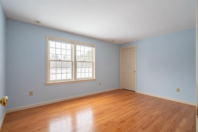 spare room with light wood finished floors and baseboards