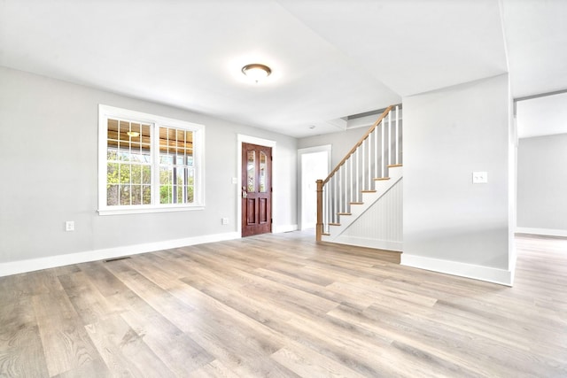 foyer entrance with stairway, light wood-type flooring, and baseboards