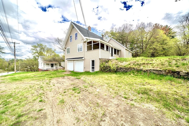 view of property exterior featuring an attached garage and a chimney