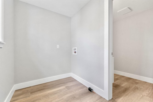 clothes washing area featuring baseboards, washer hookup, and light wood-style floors