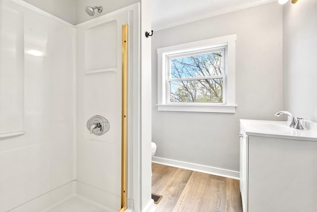 full bath featuring a shower, wood finished floors, baseboards, toilet, and vanity