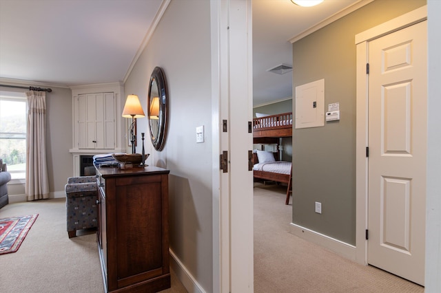 hall featuring light carpet, ornamental molding, and baseboards