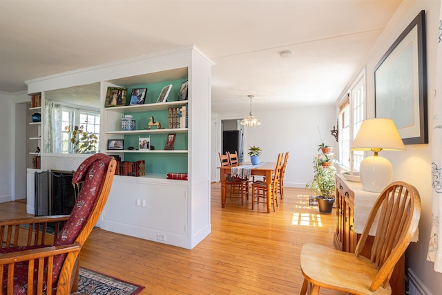 dining space with light wood-style flooring, a chandelier, and healthy amount of natural light