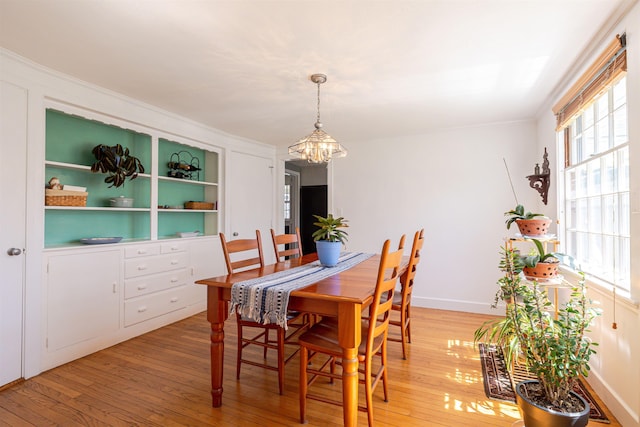dining room with a chandelier and light wood finished floors