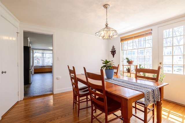 dining space with a chandelier, hardwood / wood-style floors, and ornamental molding