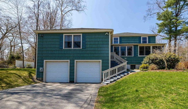 view of front of house featuring stairs, an attached garage, driveway, and a front yard