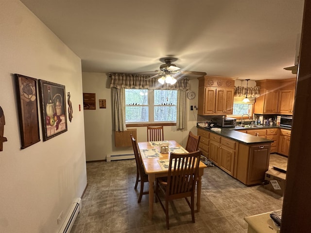 887 Harold Dow Hwy, Eliot, ME 03909 - dining room with a baseboard heating unit, ceiling fan, baseboards, and dark flooring