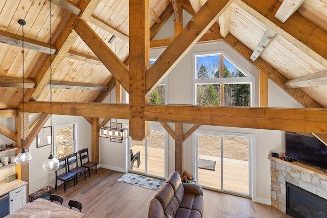 LOT22 Compass Point Rd, Thornton, NH 03285 - living room with a wood ceiling with exposed beams, light wood-style flooring, a stone fireplace, a chandelier, and high vaulted ceiling