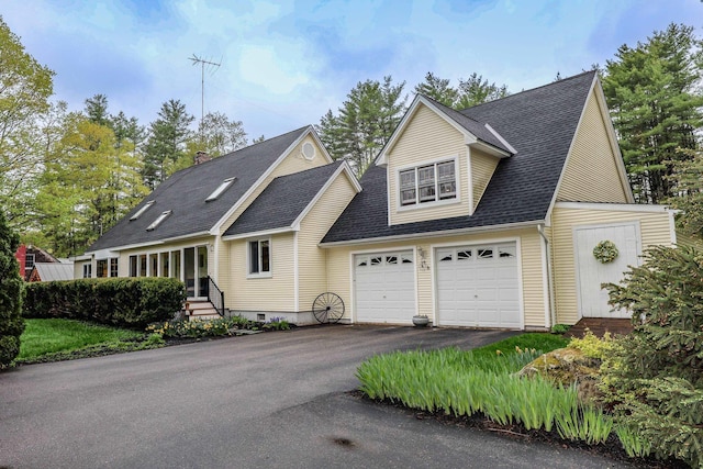 traditional-style home featuring driveway, a garage, a shingled roof, and a chimney