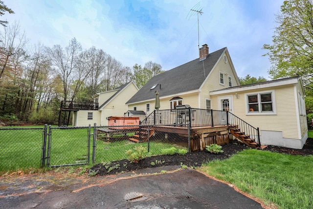 back of property with a gate, stairs, a chimney, and a deck