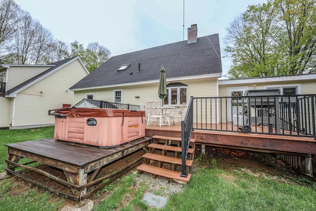 rear view of house with a hot tub, a deck, a chimney, and a shingled roof