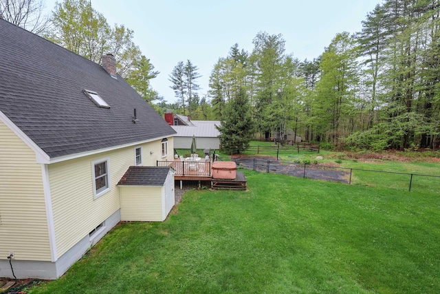 view of yard featuring a wooden deck, a shed, and an outbuilding