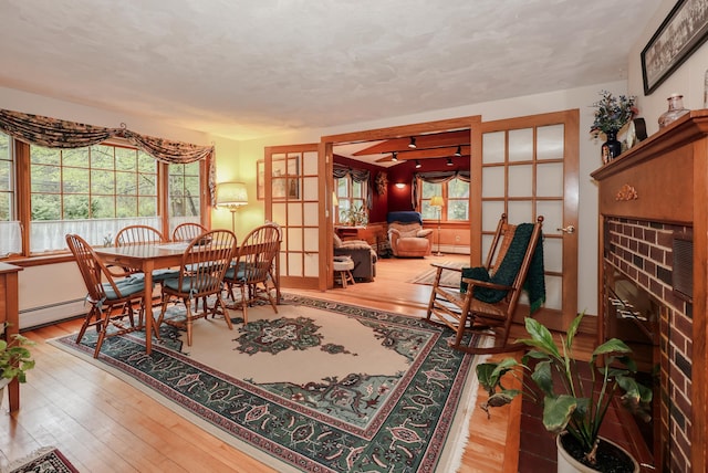 sitting room with wood-type flooring and a baseboard heating unit