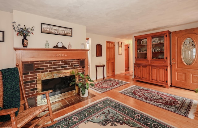 living area featuring light wood-style flooring and a fireplace
