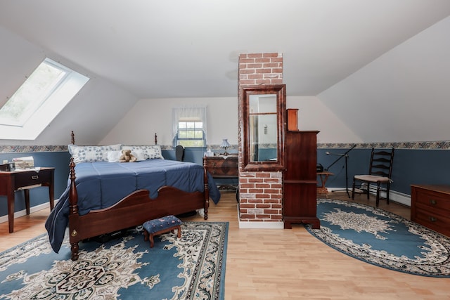 bedroom with a skylight, wood finished floors, lofted ceiling, and baseboards