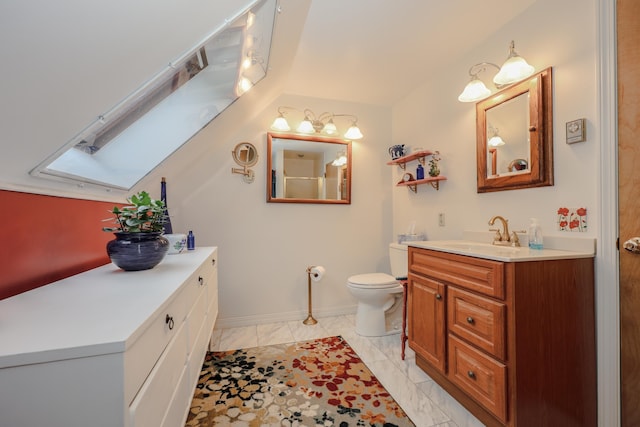 bathroom with marble look tile flooring, vanity, toilet, a skylight, and baseboards