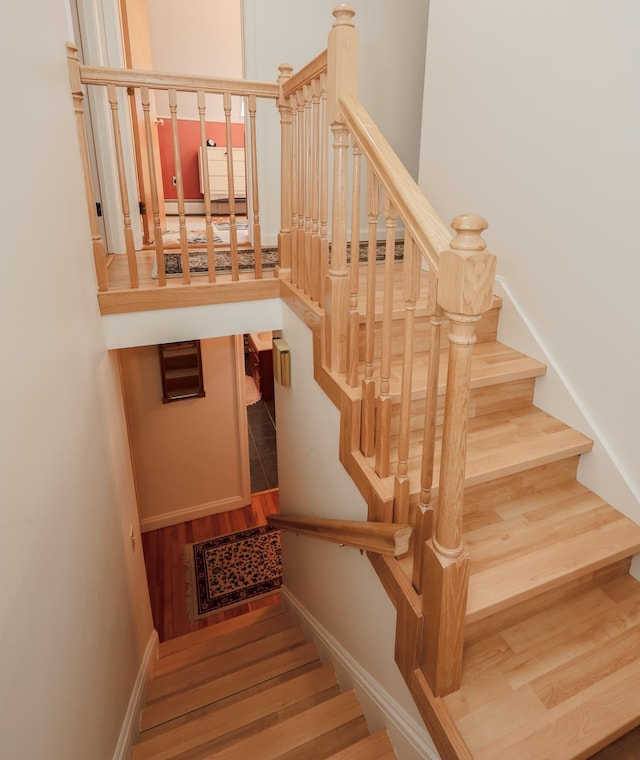 staircase with wood finished floors and baseboards