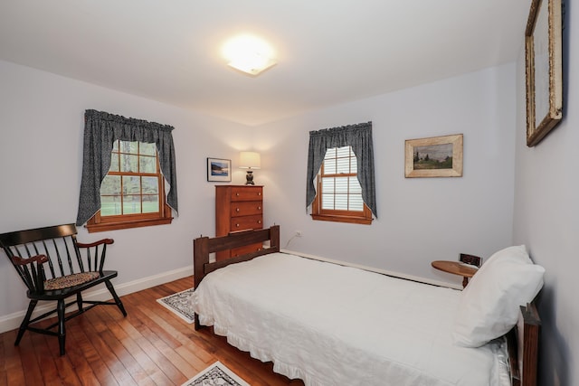 bedroom featuring hardwood / wood-style flooring and baseboards