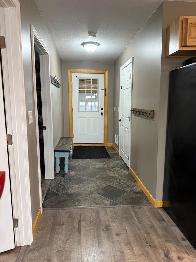 687 Chilafoux Hl, Irasburg, VT 05845 - doorway with baseboards, a textured ceiling, and dark wood-style flooring