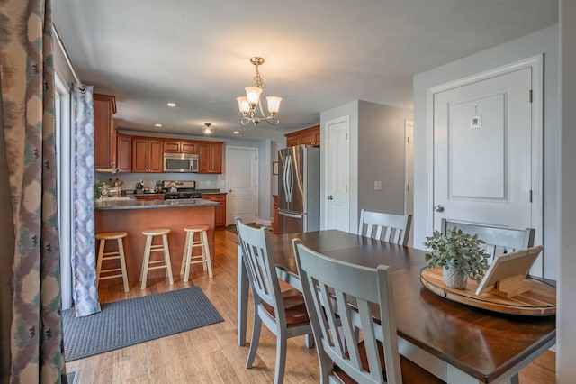 dining space featuring a chandelier, light wood finished floors, and recessed lighting