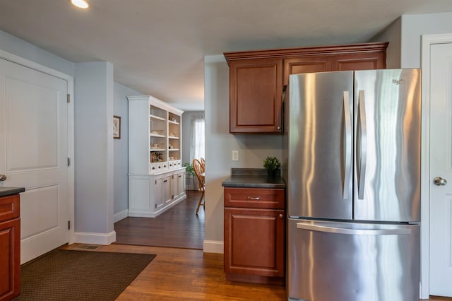 kitchen with freestanding refrigerator, dark countertops, baseboards, dark wood-style floors, and recessed lighting