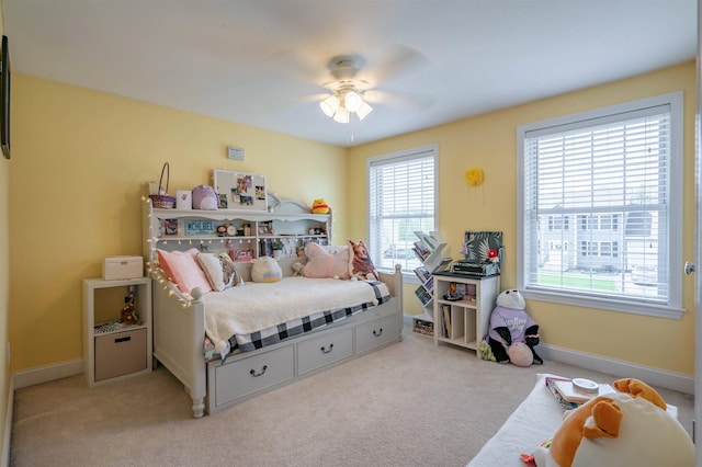 carpeted bedroom featuring baseboards and a ceiling fan