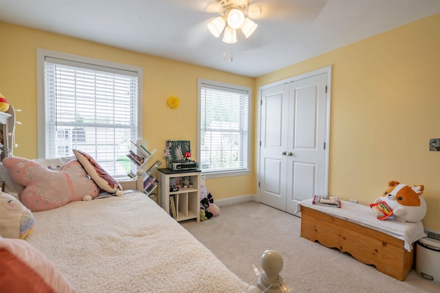 bedroom with carpet flooring, a closet, baseboards, and a ceiling fan