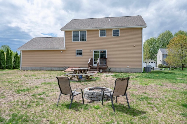 back of property featuring an outdoor fire pit, a yard, and cooling unit