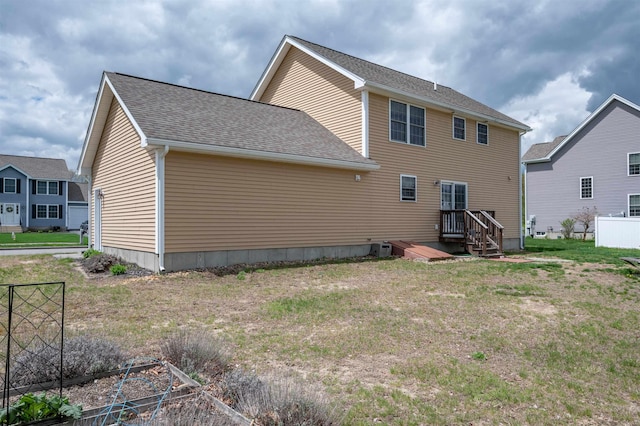 rear view of property featuring central AC and roof with shingles