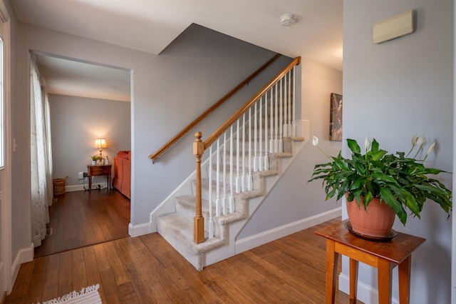 staircase featuring wood-type flooring and baseboards