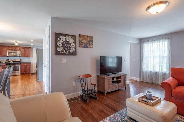 living area featuring wood finished floors, recessed lighting, and baseboards