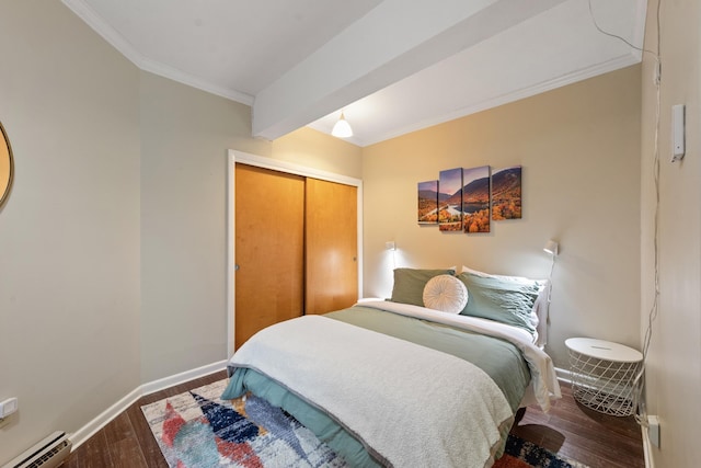 bedroom featuring wood finished floors, a baseboard radiator, ornamental molding, baseboards, and a closet