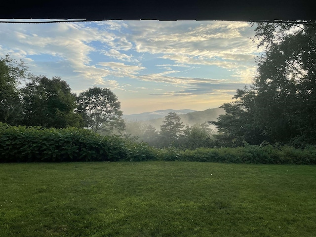 view of grassy yard featuring a mountain view