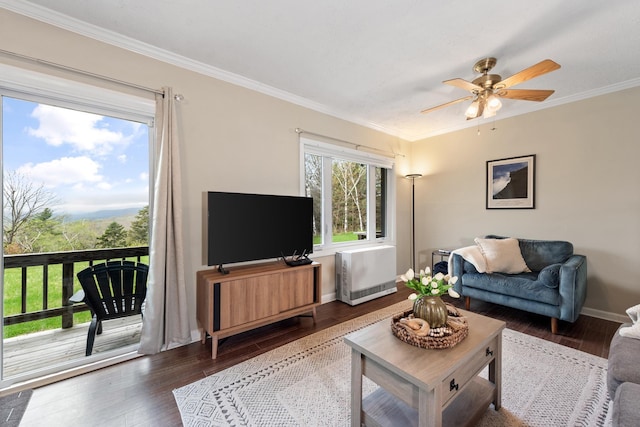 living room featuring ceiling fan, hardwood / wood-style floors, crown molding, and baseboards