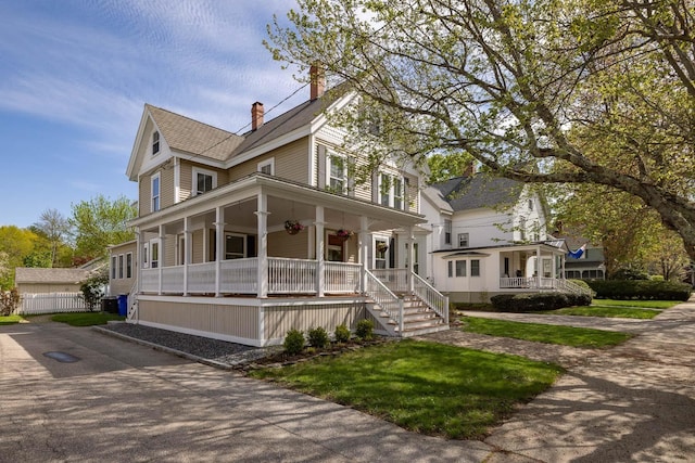 view of front of home with a porch, a chimney, and a shingled roof