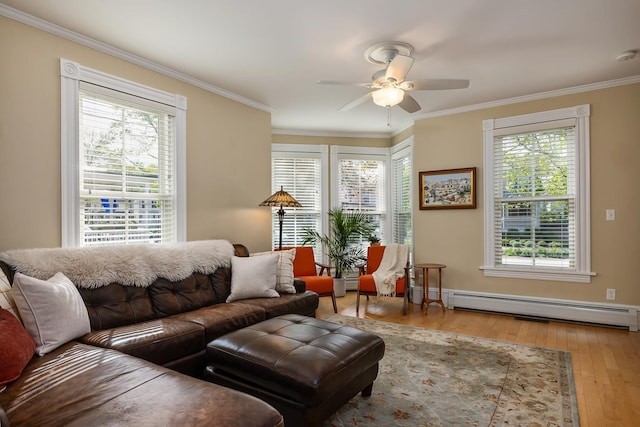 living room with a baseboard heating unit, ceiling fan, hardwood / wood-style flooring, and crown molding