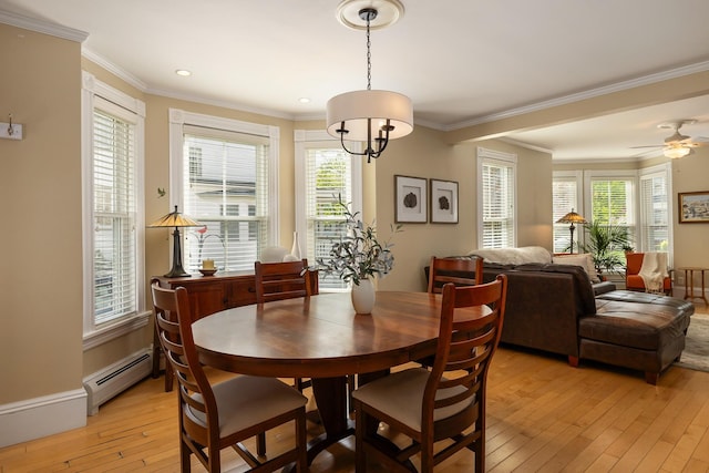dining room with baseboard heating, light wood-type flooring, healthy amount of natural light, crown molding, and recessed lighting