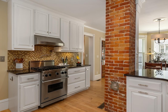 kitchen with luxury range, under cabinet range hood, ornamental molding, backsplash, and light wood-style flooring