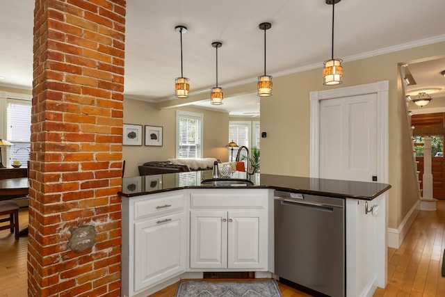 kitchen featuring stainless steel dishwasher, a sink, crown molding, light wood-style flooring, and pendant lighting