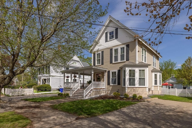 traditional style home featuring a porch and fence