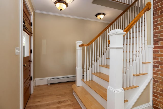 staircase with a baseboard radiator, wood finished floors, crown molding, and brick wall